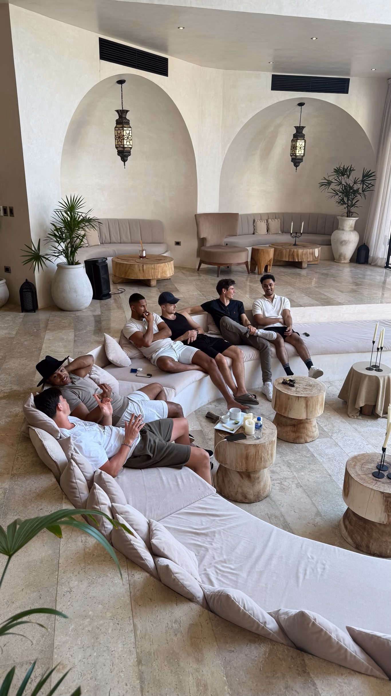 Founders unwinding on low sofas and floor cushions in a lounge at a Helix off-site — recovery built into the week