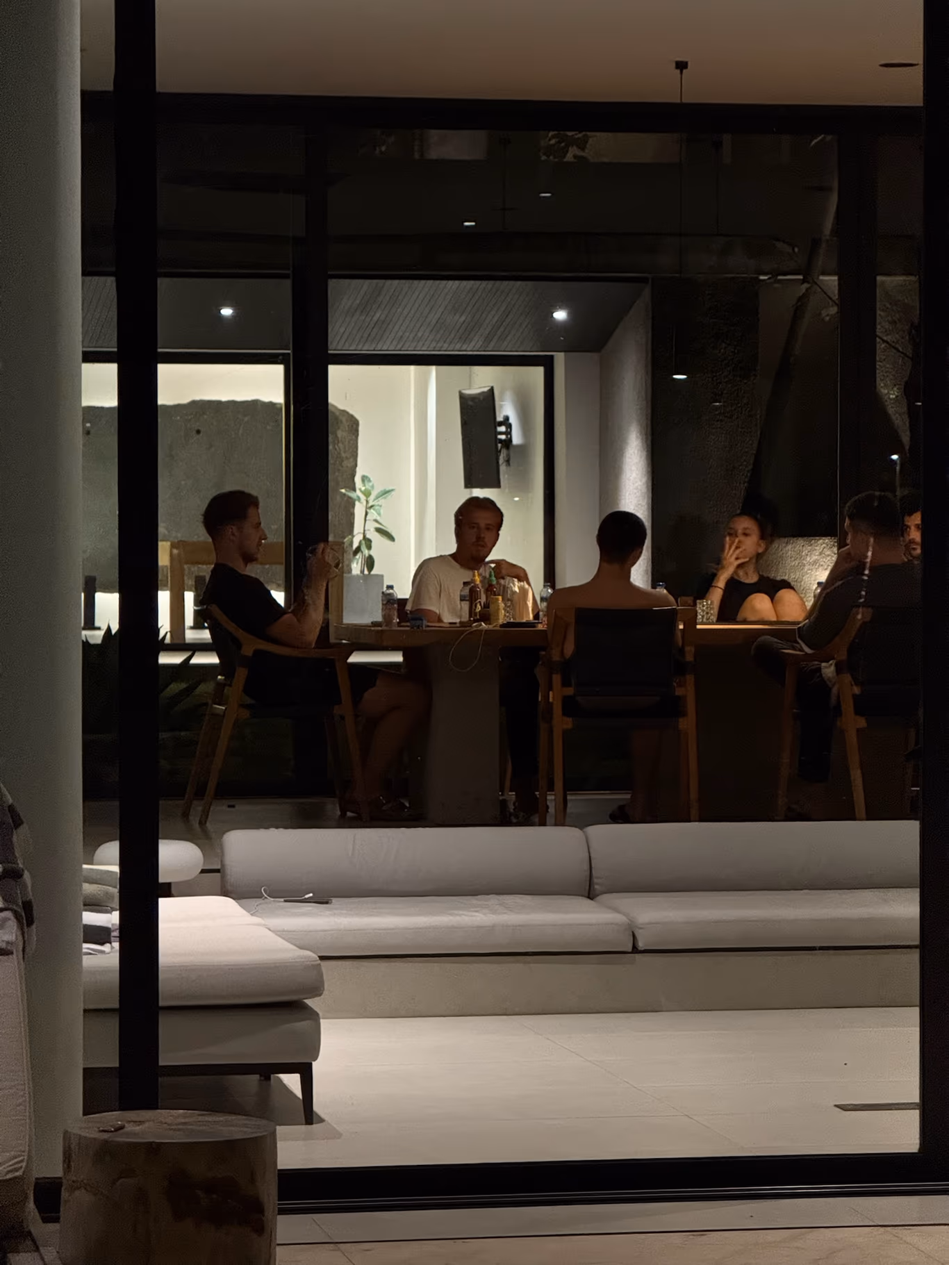 Founder community — the hours nobody scheduled Founders gathered in the evening by floor-to-ceiling windows at a Helix villa