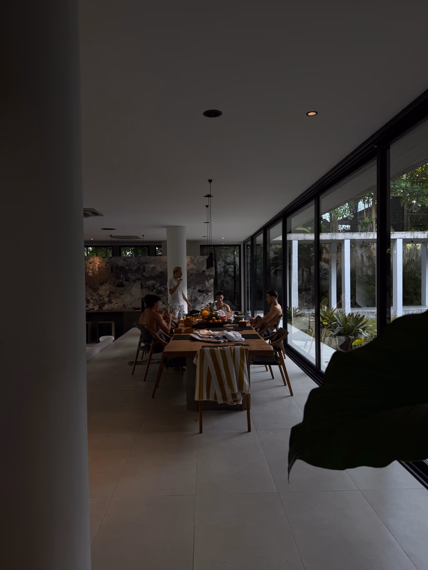 Founder loneliness — a room of people who get it A small group around a long table in a glass-walled villa room — quiet company against founder loneliness
