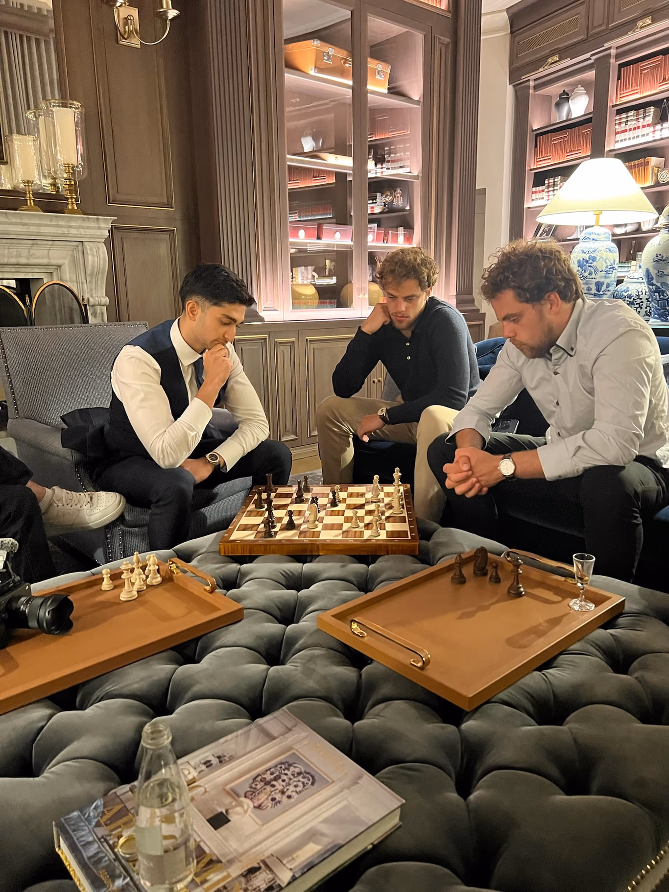 Two founders weighing a chess move while others watch — a sounding board for the hard call