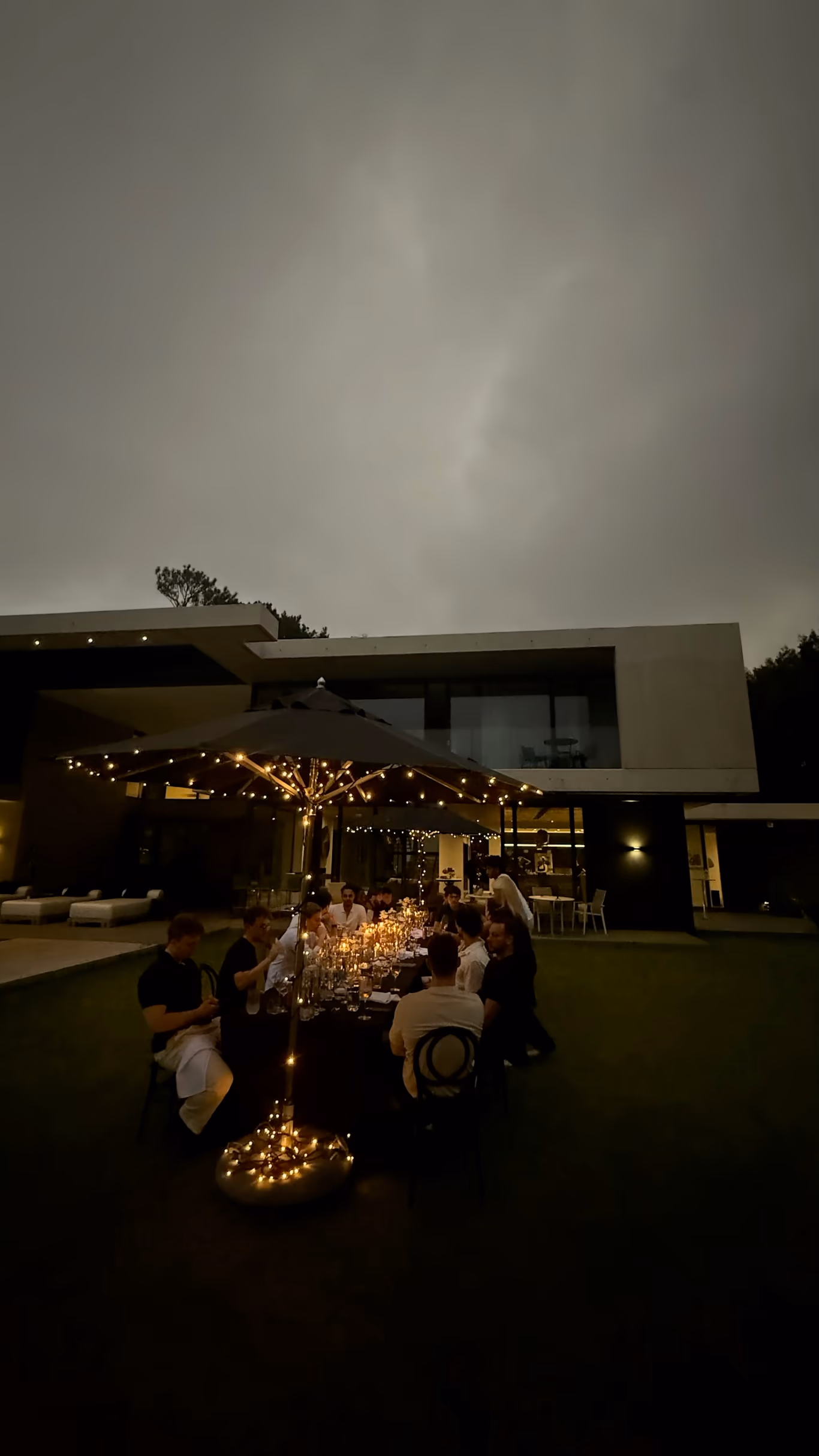 A candlelit mastermind dinner table set low and close — the format doing its work