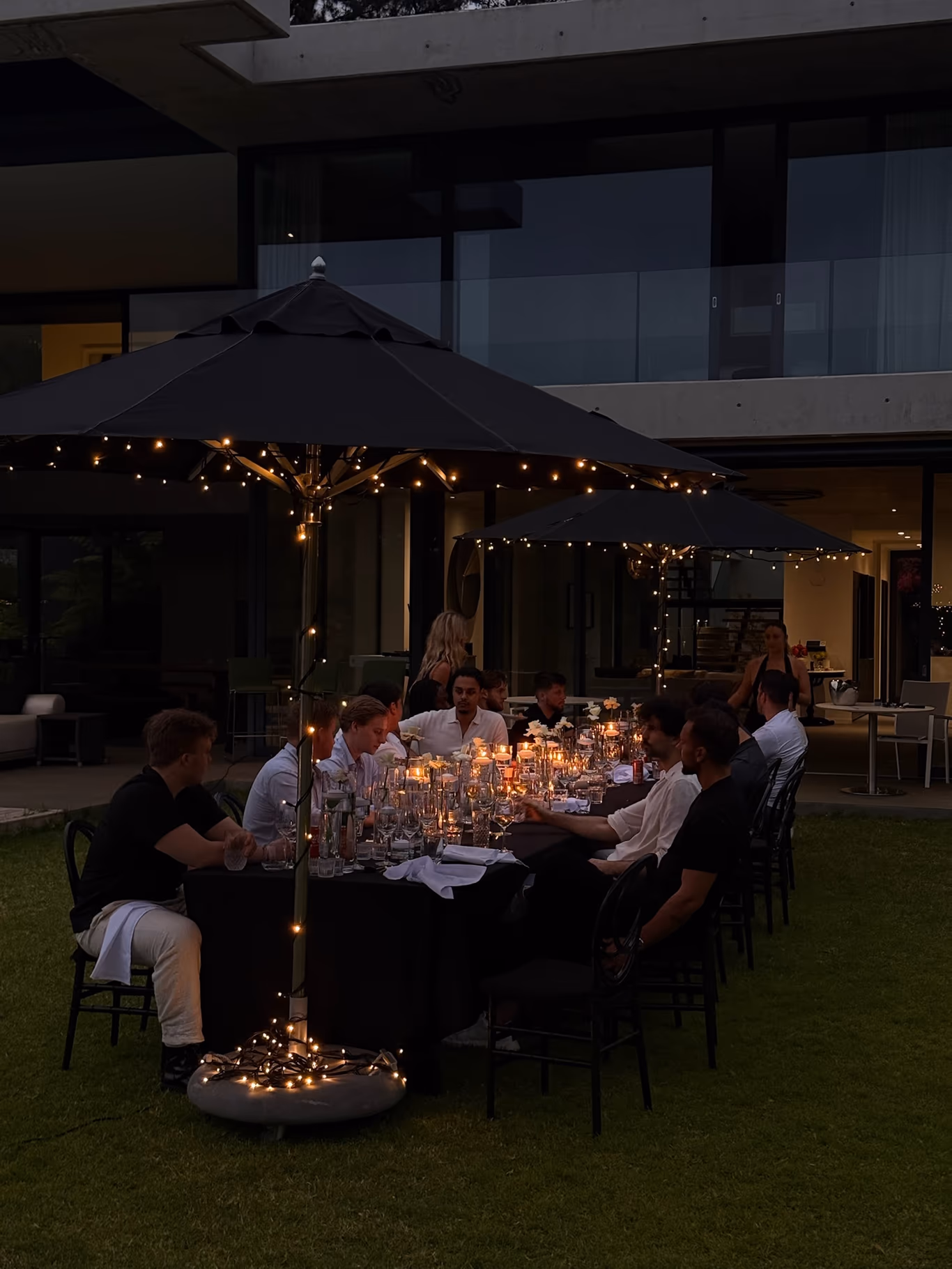 A candlelit Helix mastermind dinner at dusk — one long table, one conversation