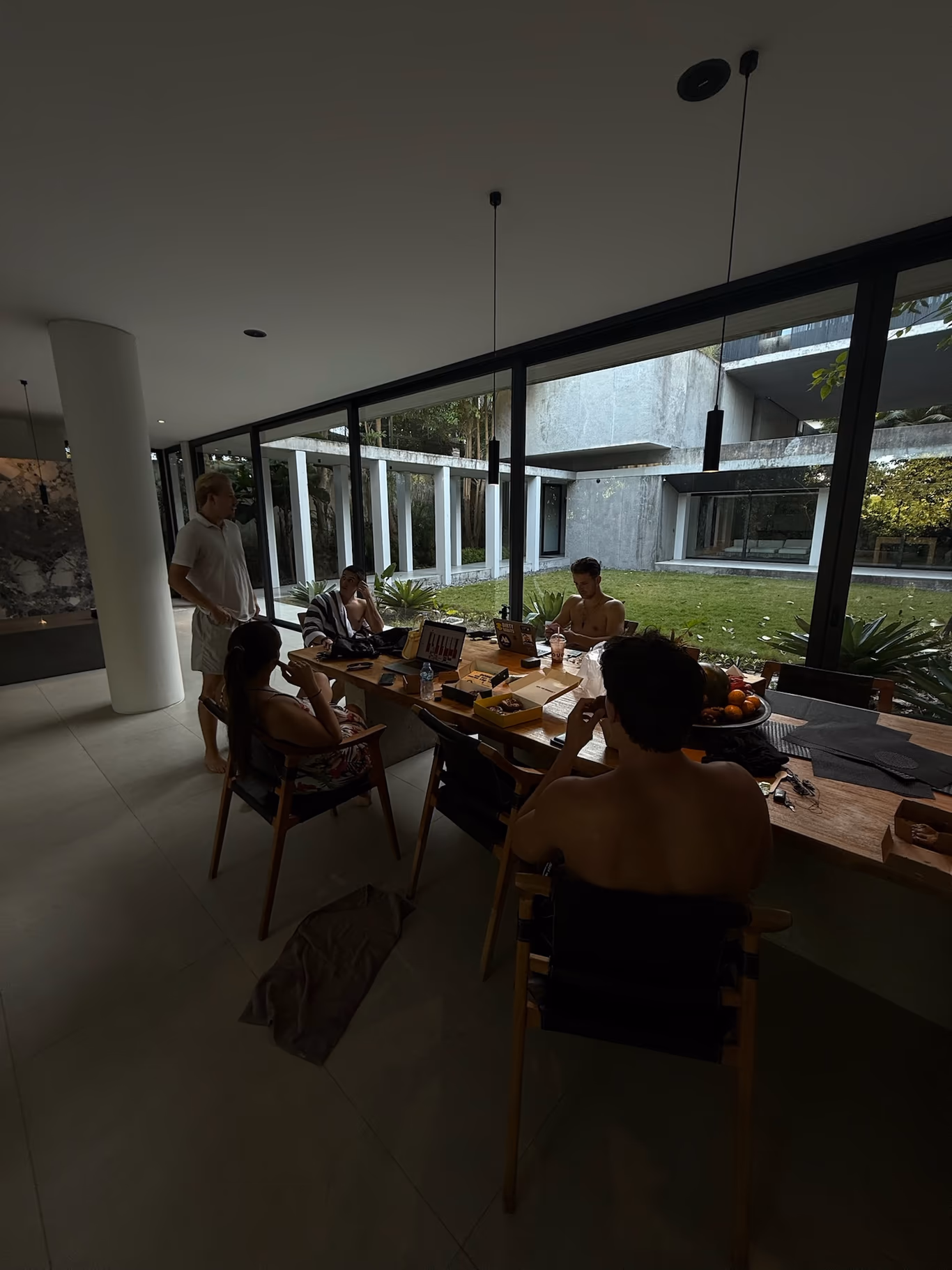 Mastermind group — the working session Founders working at a table by a wall of windows during a daytime mastermind session