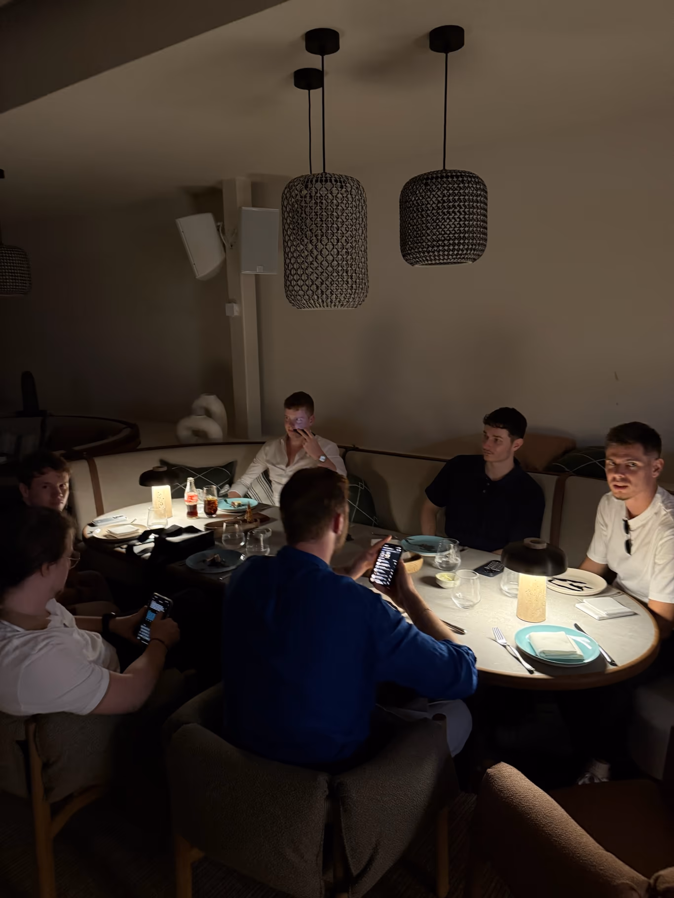 A small group of founders at an intimate, warmly lit dinner
