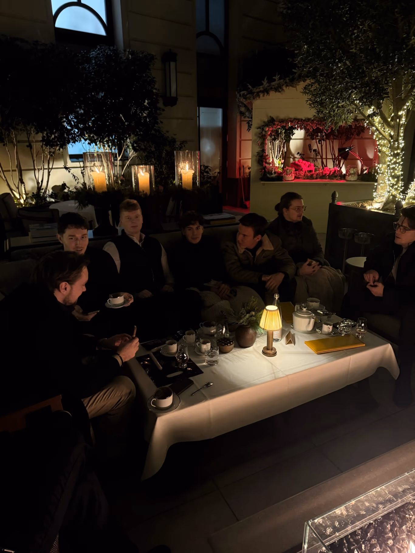 A small group of founders at an intimate, low-lit dinner — a private community by design
